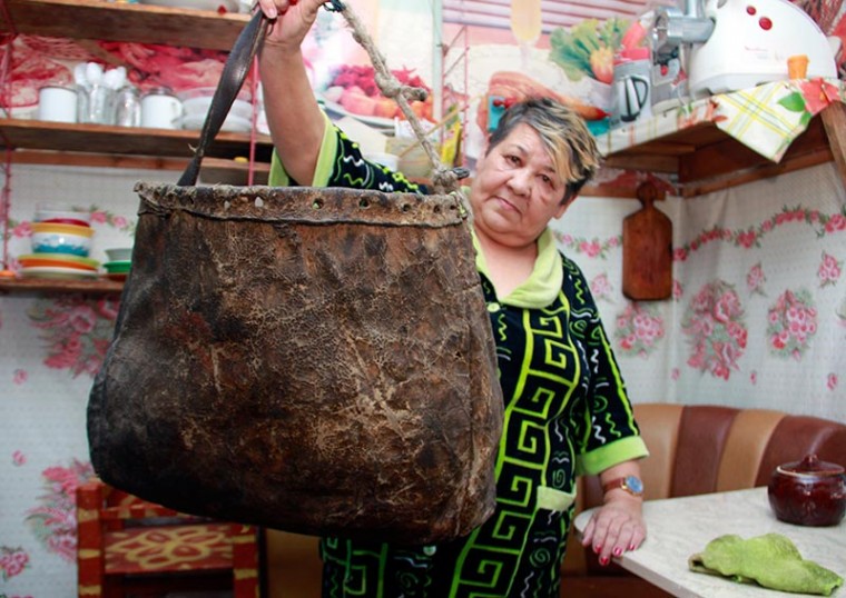 Лидия Речкина показывает сумину, сшитую из шкуры изюбря. В былые времена такие изделия использовали для перевозки вещей на оленях